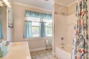 Un baño con bañera, lavabo y ventana. en Coastal Long Beach Rental with Patio, Walk to Beach!, en Long Beach 19 fotos más