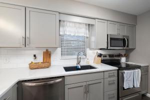 a kitchen with white cabinets and a sink at Hadley's Place at Pointe Royale, Pristine 2 Bed 2 Bath Condo in Branson