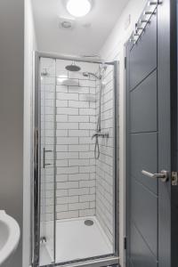 een douche met een glazen deur in de badkamer bij The Avenue Belfast in Belfast