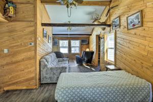 - une chambre dans une cabane en rondins avec un lit et un canapé dans l'établissement Pet-Friendly Crandon Vacation Rental Near Raceway!, à Crandon
