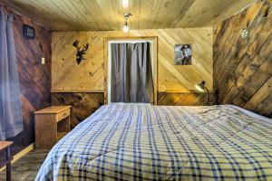 - une chambre avec un lit dans une pièce dotée de murs en bois dans l'établissement Pet-Friendly Crandon Vacation Rental Near Raceway!, à Crandon