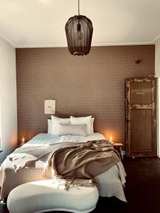 una camera con un grande letto e un lampadario a braccio di Boutique Hotel het Oude Raadhuis a Castricum