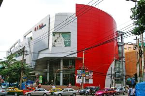 a large red building with cars on a city street at Grand Inn Hotel in Bangkok