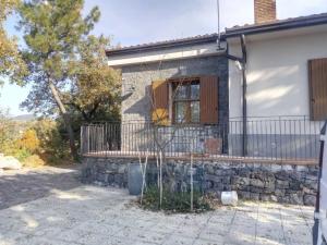 a house with a stone wall and a balcony at Casale Boschetto Etna in Biancavilla