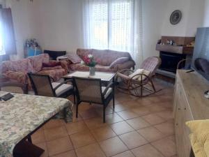 a living room with a couch and a table and chairs at Casale Boschetto Etna in Biancavilla