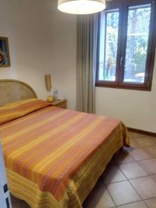 a bedroom with a bed with a orange striped blanket at Casale Boschetto Etna in Biancavilla