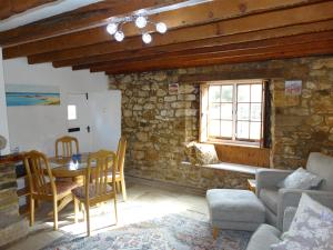 ein Wohnzimmer mit einem Sofa und einem Tisch in der Unterkunft Staddlestones Cottage in Bridport