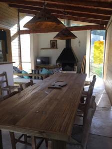een grote houten tafel in een woonkamer met stoelen bij Praia do Silveira Canto Sul in Garopaba +14 foto's