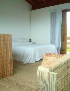 een slaapkamer met een wit bed en een raam bij Praia do Silveira Canto Sul in Garopaba