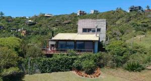 a house on a hill with people sitting on a deck at Praia do Silveira Canto Sul in Garopaba