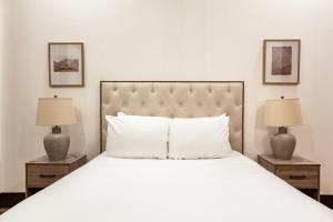 um quarto com uma grande cama branca e 2 candeeiros em Jackson Jewel - Downtown Suite em Knoxville