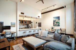 a living room with a couch and a kitchen at Jackson Jewel - Downtown Suite in Knoxville