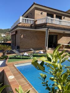 una casa con piscina frente a ella en Villa Belephant Sitges, en Canyelles