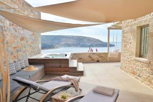 a house with a view of the ocean and a hot tub at Akrolithi Boutique Hotel & Suites in Oitylo