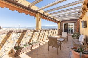 a patio with chairs and a view of the ocean at Cozy apartment in Las Gabias with a great terrace in Las Gabias
