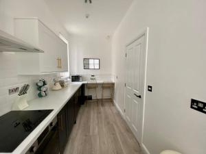 a kitchen with white counters and a white door at Air Host and Stay - Georgian Quarter - Falkner Square apartment, 2 bedroom sleeps 4 in Liverpool