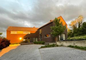 une maison avec un toit orange et une allée dans l'établissement Arcaden, à Sint-Martens-Voeren