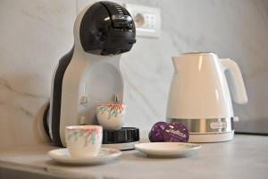 una cafetera sentada en un mostrador junto a dos tazas en Amazing View - Exclusive Apartment Portu Frailis, en Àrbatax