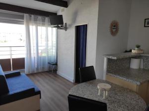 a living room with a blue couch and a table at Vacances Ambassades du Soleil in Cap d'Agde