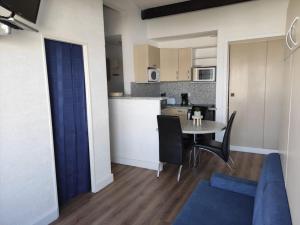 a kitchen and a dining room with a table and chairs at Vacances Ambassades du Soleil in Cap d'Agde