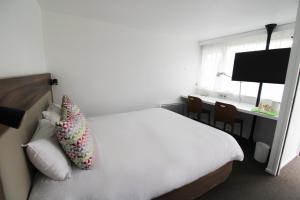um quarto de hotel com uma cama e uma secretária em Campanile Melun Sénart em Vert-Saint-Denis