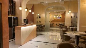 a restaurant with a bar and tables and chairs at Hotel Roma in Bologna
