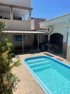 a swimming pool in front of a house at Zaca’s House in Vila Velha