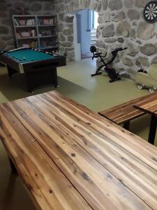 a pool table in a room with a stone wall at Gästehaus Samira in Purbach am Neusiedlersee