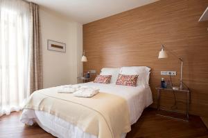 1 dormitorio con 1 cama grande y pared de madera en La Alcoba del Agua hotel boutique, en Sanlúcar de Barrameda