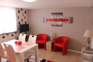 ein Wohnzimmer mit roten Stühlen und einem Tisch in der Unterkunft Skyline in Ypern