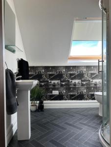 a bathroom with a toilet and a sink and a window at Atlantic Coast Lodge in Spanish Point