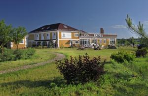 a large yellow house on a green field with a building at Paluba Hotel in Kalyazin