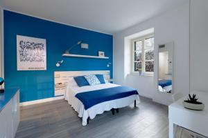 Dormitorio azul con cama y pared azul en Villa Bice, en Bergeggi