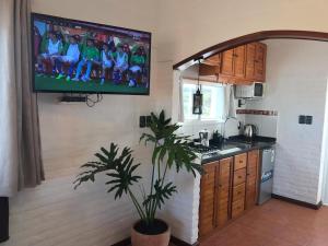 a kitchen with a tv hanging on the wall at El Diablo Chic Colonial in Punta Del Diablo