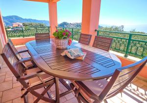 een houten tafel en stoelen op een balkon bij Villa Melissi Afionas Corfu in Afionas
