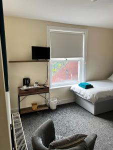 um quarto com uma cama, uma janela e uma cadeira em The Glazebury bar and restaurant with accommodation em Glazebury