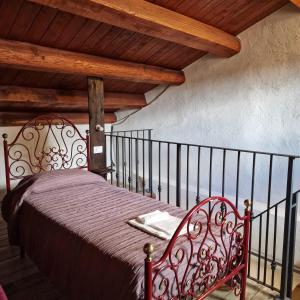 uma cama vermelha num quarto com tecto em madeira em Il pozzo dei desideri em Castelnuovo