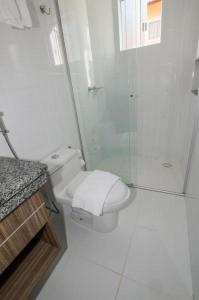 uma casa de banho branca com um chuveiro e um WC. em Lacqua Di'Roma Parque - CN M em Caldas Novas