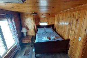 a bedroom with a bed in a wooden cabin at Riverside Cabin with Private Fishing Access! in Pulaski