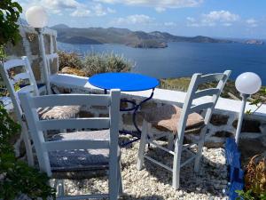 two chairs and a table with a view of the ocean at Mamos Sunset House Plaka in Plaka Milou