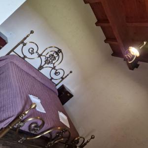 ein Schlafzimmer mit einem lila Bett und einer Lampe in der Unterkunft Il pozzo dei desideri in Castelnuovo
