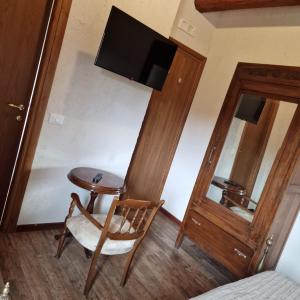 Zimmer mit einem Tisch, einem Stuhl und einem TV in der Unterkunft Il pozzo dei desideri in Castelnuovo
