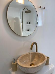 a bathroom with a stone sink and a mirror at Mamos Sunset House Plaka in Plaka Milou