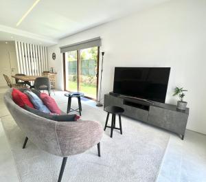 a living room with a couch and a flat screen tv at Vila Ruby - Private Pool by HD PROPERTIES in Vilamoura
