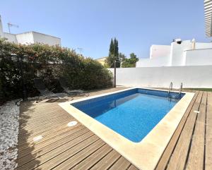 a swimming pool on a wooden deck with two chairs next to it at Vila Ruby - Private Pool by HD PROPERTIES in Vilamoura