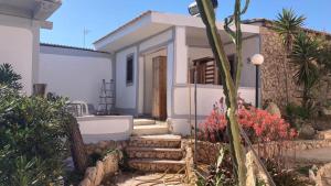 una piccola casa bianca con le scale di fronte di B H Lampedusa a Lampedusa