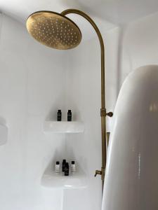 a bathroom with a lamp and some bottles on shelves at Mamos Sunset House Plaka in Plaka Milou
