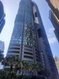 Un edificio alto con palmeras delante. en Sky Suites KLCC by KD Sky Home, en Kuala Lumpur