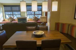 uma sala de jantar com uma mesa de madeira e cadeiras em Grand Summit G463 em Park City