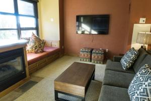 uma sala de estar com um sofá e uma televisão em Grand Summit G463 em Park City